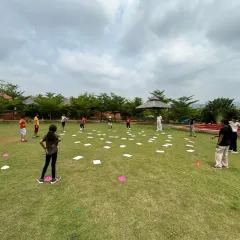 Kids engaged in a dynamic team-building activity on a grassy field. These games are designed to foster communication, collaboration, and problem-solving skills in a fun way.
