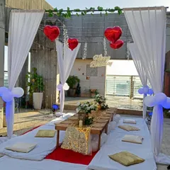 A daytime view of the terrace dinner setup, showing the clean white and red color palette. We can adapt this floor seating arrangement for various small-scale events.