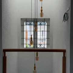 If you can’t decide between symmetry and surprise, do both. A cluster of hanging pendant lights creates a beautiful, cascading effect in this stairwell.