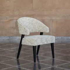 The 'Adira Chair', named for the Sanskrit word for "strong." Handcrafted by local artisans from solid oak, its sleek yet sturdy construction, gently curved back, and cushioned seat offer a statement in sustainable design and comfort.