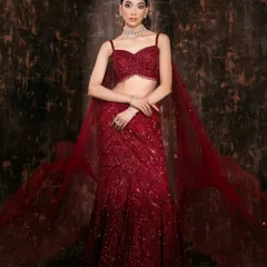 The full vision of a modern bridal look. The movement in the flowing red lehenga and the confident pose create a powerful silhouette against a moody, textured backdrop. This is how we build a complete story for a designer's collection.
