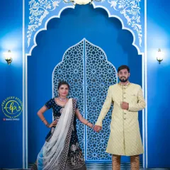 I offer regal ethnic wear for couples, like this navy blue embroidered lehenga and a light yellow patterned sherwani. This combination is perfect for a grand, palace-themed photoshoot.