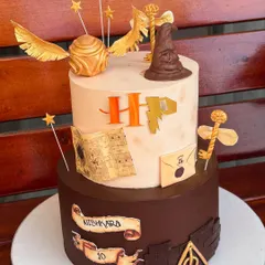 For the ultimate Potterhead, we designed this magical two-tier Harry Potter cake. It's packed with iconic, handmade fondant details like the Sorting Hat, Golden Snitch, and a letter from Hogwarts, making it a truly enchanting centerpiece.