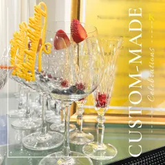 Custom-made celebrations are our specialty. This image shows our elegant crystal glassware prepared with fresh berries and personalized yellow stirrers, ready to be filled with a signature cocktail.
