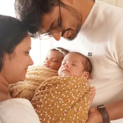 A close-up of the parents' faces as they lovingly gaze at their newborn twins. This shot is all about the deep connection and overwhelming love of a new family.