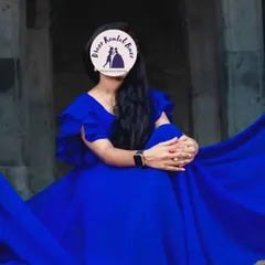 A client wearing our royal blue flying dress, seated for a portrait that showcases the dress's rich color and flowing fabric.