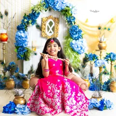 A beautiful little Radha holding a flute, with a radiant smile. I provide a complete wardrobe with traditional outfits and jewelry for these special shoots.