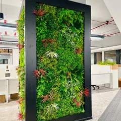 A close-up of the artificial vertical garden, showing the variety of textures and colors used to mimic a natural wall. These installations are completely maintenance-free, making them ideal for busy corporate settings.