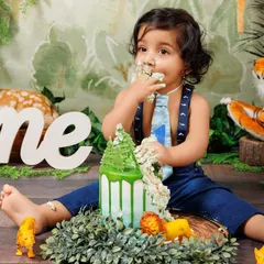 The aftermath of a fun cake smash! This little boy is covered in cake and happiness after his jungle-themed celebration.