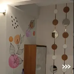 For a truly unique touch, we offer hand-painted wall art. This abstract botanical mural was designed to add a playful and artistic element to the corner of a room, showcasing our ability to create custom designs.