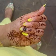 A unique combination of a vibrant yellow French tip and custom hand-painted evil eye art on an almond-shaped nail extension.