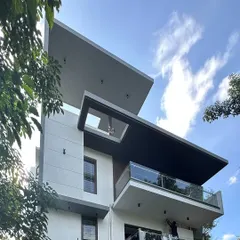 The 'Madhuram' project nearing completion, showing its bold, cantilevered rooflines and deep balconies that create a powerful architectural statement.
