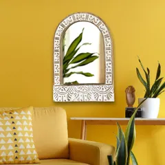 See how this jharokha-inspired arched mirror transforms a simple wall into a statement. The distressed white finish on the hand-carved mango wood provides a beautiful contrast against a vibrant color, making it a perfect focal point for a living room or entryway.
