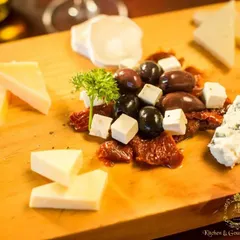 A close-up of a cheese platter featuring blue cheese, feta, and other varieties, artfully arranged with sun-dried tomatoes and olives. This demonstrates the detailed composition of my boards.