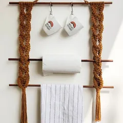 This macrame kitchen hanger is a great space-saver. It has two wooden dowels for hanging kitchen towels or paper towel rolls, and you can add hooks to the top bar for mugs or utensils.