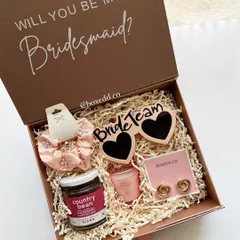 A fun and stylish "Will you be my Bridesmaid?" proposal box. This hamper includes 'Bride Team' sunglasses, a scrunchie, gourmet coffee, and other treats, all packed beautifully to get your friends excited for the journey ahead.