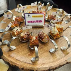 Presentation matters. Here, I serve "China Garden" appetizers on individual spoons arranged on a rustic wooden platter, making it easy for guests to grab a bite while mingling.