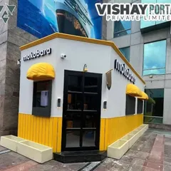 Here’s a front-on view of the Mokobara kiosk. You can see the clean lines, the glass-paneled door that offers a peek inside, and the custom yellow awnings that match the brand's colors perfectly. Every detail is designed to create a cohesive brand experience.