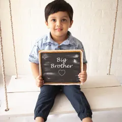 Getting ready to be a big brother! This simple and sweet portrait on our studio swing is a perfect way to announce a new family member.