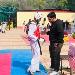 A moment of intense focus between rounds. Here, a fellow coach provides tactical guidance to Ansh Sharma during a tough match. We work as a team to support our fighters.
