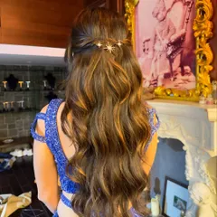 A touch of celestial magic for a cocktail look. This half-up style with soft waves is elevated with delicate star-shaped hairpins for a dreamy finish.