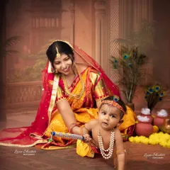 A playful moment from the Krishna-themed shoot, capturing the baby crawling while his mother looks on with a smile.
