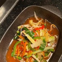 A close-up of one of our signature Pan-Asian dishes. This bowl features crisp, stir-fried vegetables like baby corn and bell peppers in a savory sauce, delivering authentic Asian flavors perfect for any luxury gathering.