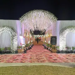 A dreamy floral entrance for an outdoor wedding. We created multiple arches covered in white flowers leading into a tunnel with a ceiling of hanging wisteria, making for a magical walk-in experience.