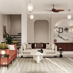 Another view of the living room, highlighting the interplay of color and form. The space is designed to feel balanced and simple, where the vibrant coral-pink sofa provides a focal point against the minimalist backdrop of white walls and marble accents.