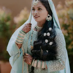A stunning portrait of a Muslim bride in her beautiful light blue attire, with delicate flowers in her hair.