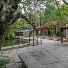 A view of the stone-paved courtyard featuring our iconic swing, with the Pond Pavilion in the background. This highlights the blend of natural and architectural beauty at our venue.
