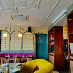 A cozy corner in my house, with a bright yellow couch and eclectic wallpaper. Every detail is designed to make you feel at home.