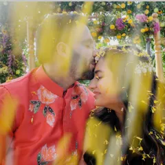 A close, romantic moment amidst a shower of flower petals. This shot beautifully combines the tenderness of their relationship with the fun, floral theme of their personalized shoot.