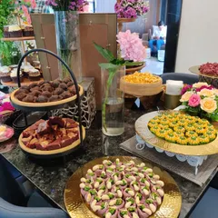 A colourful display of traditional Indian sweets and modern desserts at a housewarming party. We love to create spreads that blend different culinary styles to cater to diverse tastes.