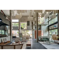 The interior of the Magari furniture store in Hyderabad was conceived as a multi-level experience. We used raw concrete and suspended fabric panels to define spaces without solid walls, allowing natural light from large windows to illuminate the craftsmanship of the furniture on display.