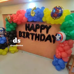 An action-packed Avengers theme for a 6th birthday. This setup features a colorful balloon arch with character foils of Captain America, Iron Man, and Spider-Man against a neutral backdrop.