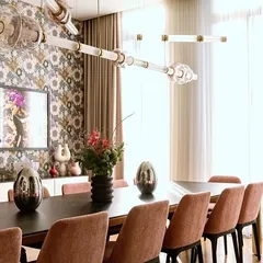 A custom configuration of the Luna Kaleido series in a dining room with bold wallpaper. The colored mouth-blown glass beads and metal finishes can be tailored to complement any interior palette.