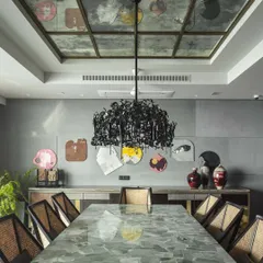 The dining room at 'The 42, Kolkata' project, featuring a custom dining table made from light green aventurine stone. We paired it with our own cane-woven chairs and a dramatic Brand van Egmond chandelier to create a space that balances raw materiality with refined elegance.