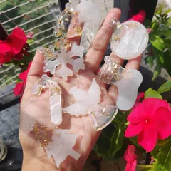 A handful of custom resin Christmas ornaments I made for a client. The set includes a snowflake, angel, candy cane, and other festive shapes, all with a pearly white finish and gold leaf.