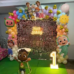 Another angle of the Cocomelon birthday setup, showing the full arrangement with the number '1' marquee light and character props.