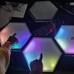 This is the 'Canvas Beats' team with their Breakthrough Award-winning project at the FIRST LEGO LEAGUE (FLL) challenge. They created these incredible touch-sensitive hexagonal light pads, showing amazing progress in both their technical skills and confidence.