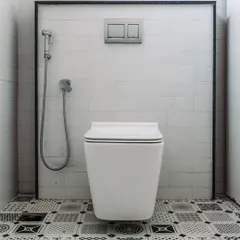 A study in black and white. The geometric pattern of the floor tiles contrasts with the simple white subway tiles on the wall, creating a bold and graphic bathroom design.