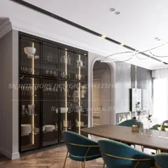 A sophisticated, full-height crockery cabinet with black frames and glass doors. Integrated vertical lighting beautifully illuminates the glassware and dishes stored inside, turning everyday items into a design feature.