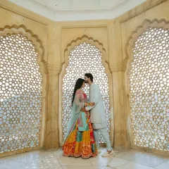 Inside the historic walls of Amber Fort, I use the intricate jali windows to frame your connection. It’s about finding those quiet, intimate moments amidst the royal splendor, creating a timeless portrait of your love.