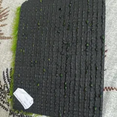 The underside of the 50mm football turf, showing the heavy-duty backing with drainage holes. This construction ensures stability and allows water to pass through easily.