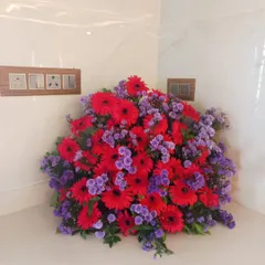 A beautiful floor bouquet with red gerberas and purple statice flowers. This type of arrangement is perfect for filling a corner or placing next to a stage or entrance.