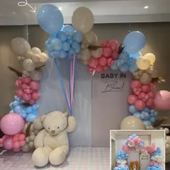 The final result of a "Baby in Bloom" gender reveal party. The pink and blue balloon arch with a central teddy bear creates a perfect photo op.