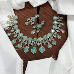 A stunning AD necklace set laid out to show its full design. This piece is available in multiple vibrant colors like ruby red, emerald green, pastel blue, and sapphire blue, featuring teardrop-shaped stones.