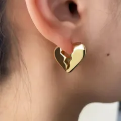 A model shot of the unique broken heart gold plated earrings, a modern and edgy design for a subtle statement.