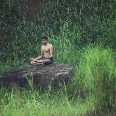 Finding strength in stillness. I believe true wellness comes from connecting with nature and your inner self. This is me in a seated meditation pose on a rock, a practice I teach to build mental focus and calm.